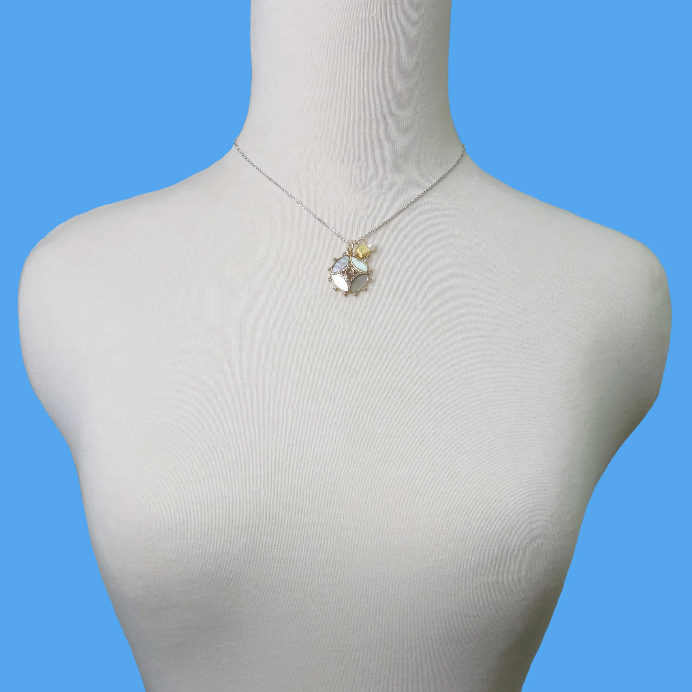 She Gleams: diamonds, mother of pearl in gold necklace